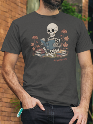 Skeleton reading a blue book surrounded by flowers and stacked books with “#myafterlife” text printed on an asphalt grey t-shirt | Smolt