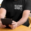 “Reluctant Author” typography with a minimal trash can illustration printed in white on a black t-shirt | Smolt