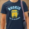 “Bookie – All In On Books” graphic with a yellow slot machine illustration printed on a navy blue t-shirt | Smolt