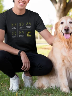 Dog ear expression chart graphic with humorous captions including “I run this house,” “Belly rubs now,” and “I am all ears” printed in yellow and white on a black t-shirt | Smolt