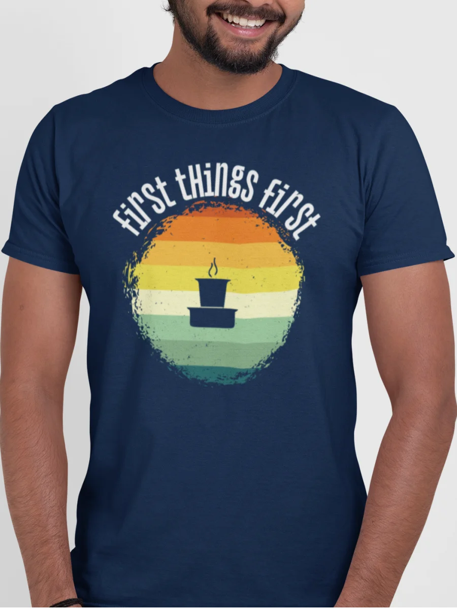 “First Things First” retro sunrise graphic with a filter coffee tumbler illustration printed on a navy blue t-shirt | Smolt