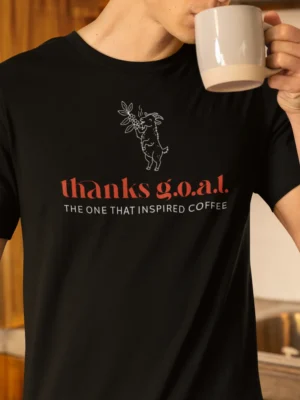 “thanks g.o.a.t. the one that inspired coffee” typography graphic with a goat and coffee plant illustration printed on a black t-shirt | Smolt