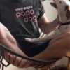 “papa dog” typography graphic with crossed-out “dog papa” text printed in pink and white on a black t-shirt | Smolt